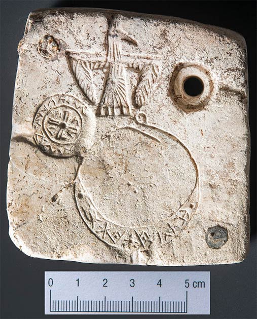 Gravuren auf der Rückseite des Artefakts mit dem Rabensymbol an der Spitze.