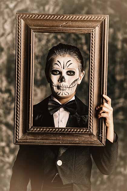 Ein als Baron Samedi verkleideter Junge