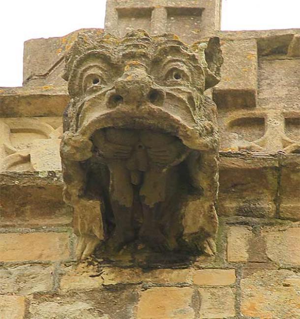 Die männliche Darstellung im Maul eines Wasserspeiers in der Kirche St. Michael the Archangel's Church in Laxton, Nottinghamshire, aus dem 12. Jahrhundert, die laut Sheelangig.org „das Motiv des Exhibitionisten mit dem des verschlungenen Sünders“ kombiniert.