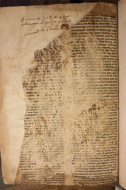 Eine Nahaufnahme eines der Fragmente, die Schäden am Text und eine Inschrift im Wirtsband zeigt.