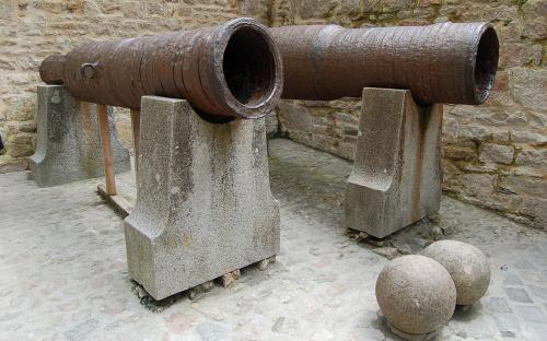 Kanonen, die am 17. Juni 1434 von Thomas de Scales, 7. Baron Scales, am Mont Saint-Michel aufgegeben wurden. Seit Juni 2013 ist nur noch die zweite Kanone, die näher an der Wand, im Inneren des Eingangs zur Außenwand des Monts zu sehen. (Public Domain)