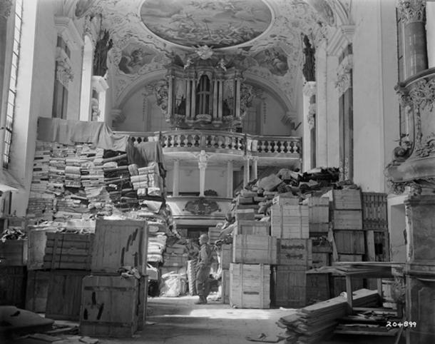 Ein amerikanischer Soldat im April 1945 steht unter dem Kulturgut, das von den Nazis geplündert und in der Schlosskirche Ellingen gelagert wurde.