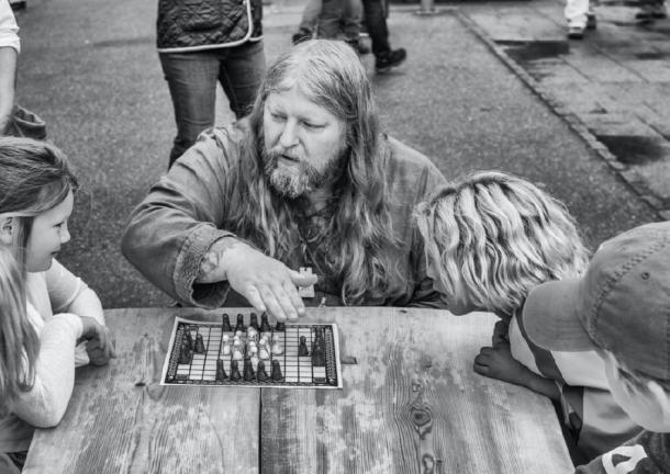 Ein „Wikinger“ zeigt, wie man das alte Brettspiel „hnefatafl“ spielt