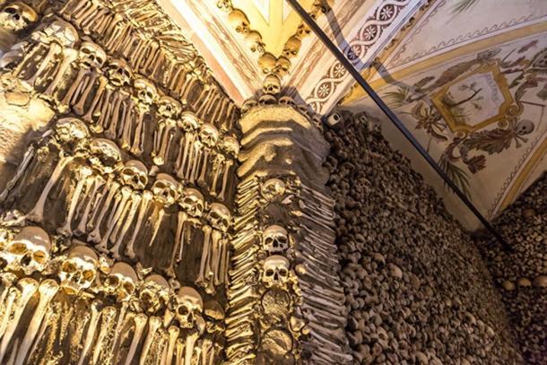 Knochenkapelle in Portugal, wo eine riesige Wand mit Knochen und Schädeln ausgestellt ist.