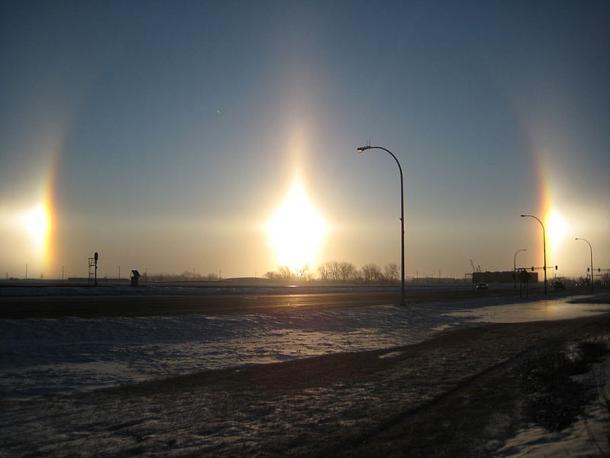 Sehr helle Nebensonnen in Fargo, North Dakota. Ebenfalls sichtbar sind Teile des 22°-Halos (die Bögen, die durch jede Nebensonne verlaufen), eine Sonnensäule (die vertikale Linie) und der parhelische Kreis (die horizontale Linie).