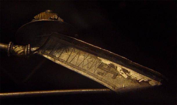 Silberfibel (DR EM85;123) (eine alte Brosche), gefunden in Værløse, Seeland, Dänemark. Die proto-nordische Runeninschrift in Elder Futhark lautet „alugod“. Nach Angaben des dänischen Nationalmuseums, in dem sie ausgestellt ist, stammt die Spange aus dem 3. Jahrhundert nach Christus.