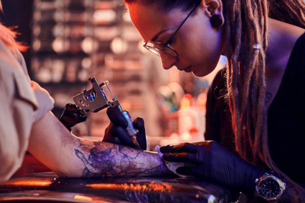Tattoo-Künstlerin bei der Arbeit