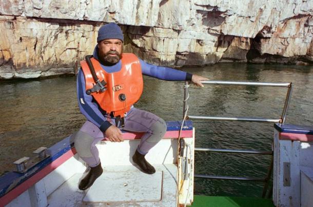 Henri Cosquer, der Taucher, der die Höhle gefunden hat, fotografiert auf einem Boot über dem Eingang im Jahr 1991