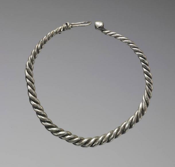 Dieser Wikinger-Halsring besteht aus drei gedrehten Silberdrähten und wird mit einem ungewöhnlichen konischen Knopf und einer Schlaufe verschlossen. Er war für seinen Besitzer sowohl Schmuck als auch Geld. Große Halsringe und kleinere Armringe wurden in den Horten der Wikinger in Irland, Skandinavien und England vergraben, allesamt wichtige Knotenpunkte des Seehandels der Wikinger. Dieser Halsring wurde 1880 in Fenit, County Kerry, Irland, zusammen mit einem schlichten Armring entdeckt.