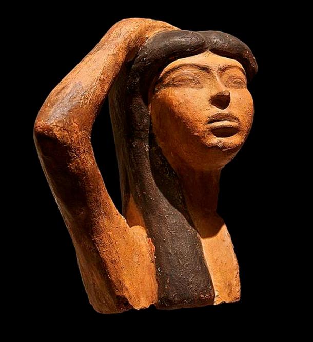Ein seltenes Exemplar einer ägyptischen Terrakotta-Skulptur stellt Isis dar, die um Osiris trauert. Die Skulptur zeigt eine Frau, die ihren rechten Arm über ihren Kopf hebt, eine typische Geste der Trauer.